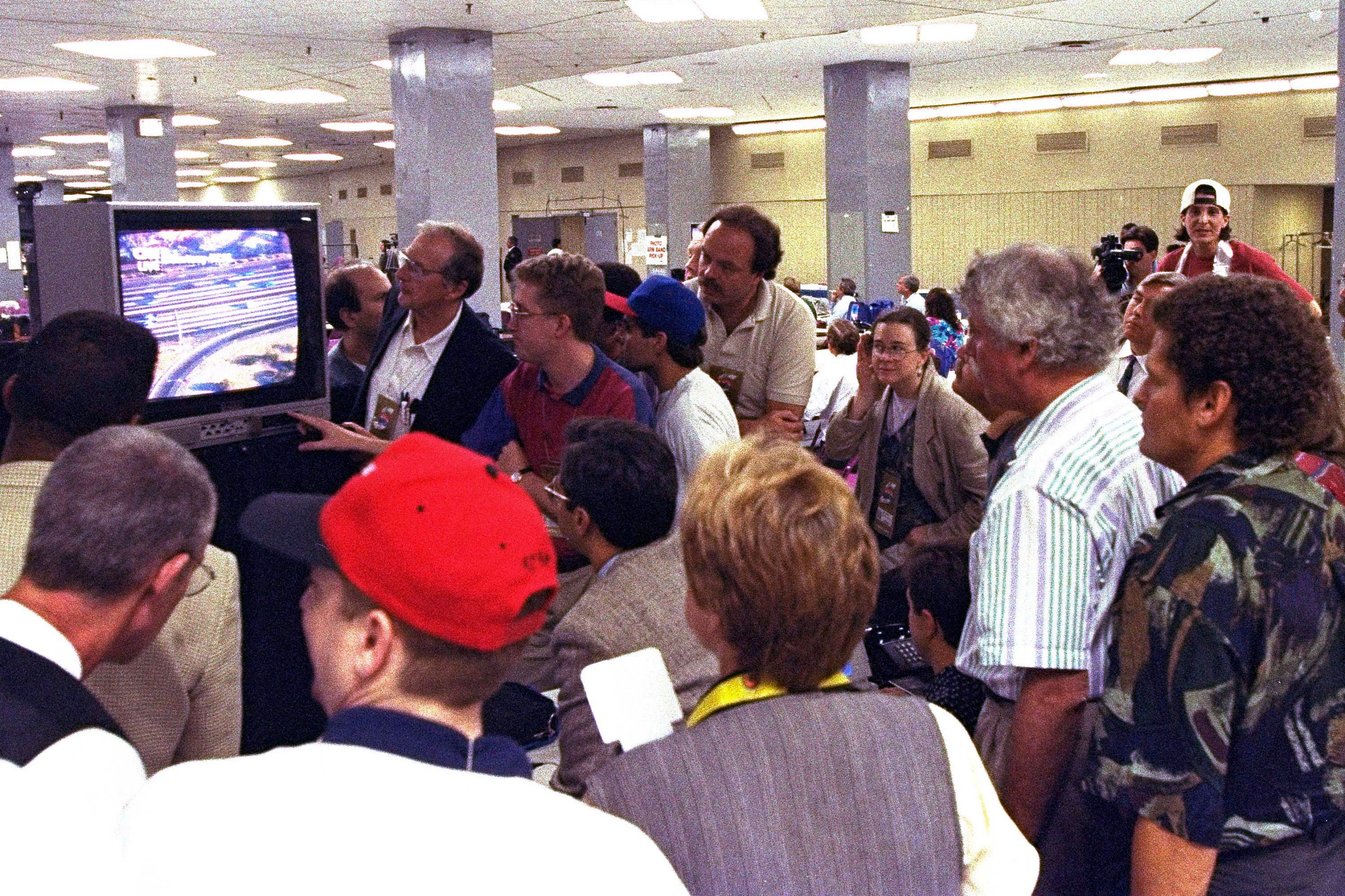Members of the news media watch live television coverage of the O.J. Simpson slow speed chase on Los Angeles freeways during Game 5 of the NBA finals in New York City
