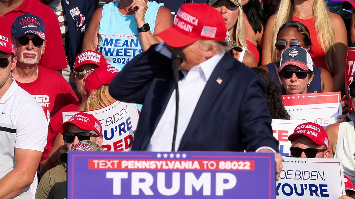 Donald Trump reacts as multiple shots rang out during a campaign rally