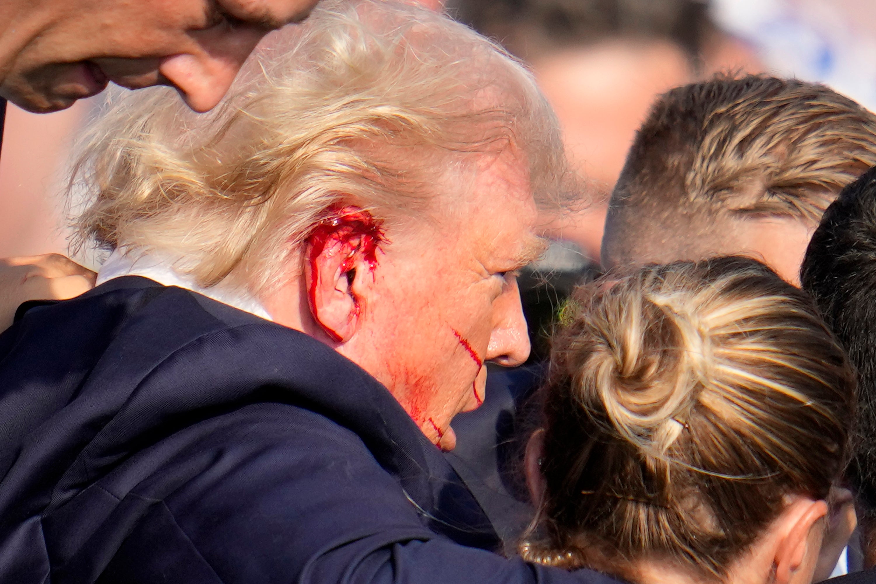 Republican presidential candidate former President Donald Trump is escorted to a motorcade following an attempted assassination at a campaign event in Butler, Pa., on Saturday, July 13, 2024.