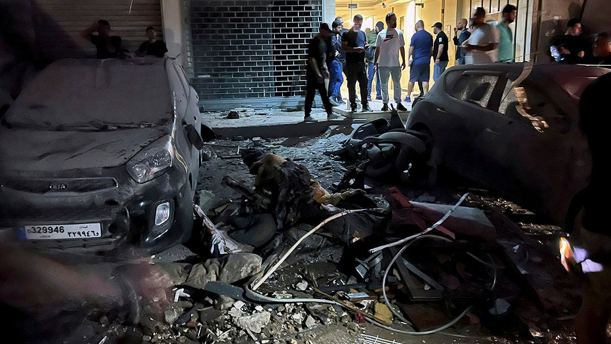 People inspect damaged cars in the southern suburbs of Beirut on Tuesday, July 30, 2024. An Israeli airstrike hit Hezbollah's stronghold south of Beirut Tuesday evening causing damage, a Hezbollah official and the group's TV station said.