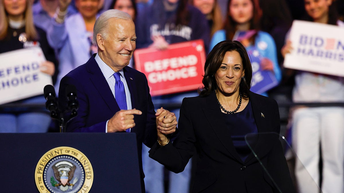 Joe Biden holding Kamala Harris' hand