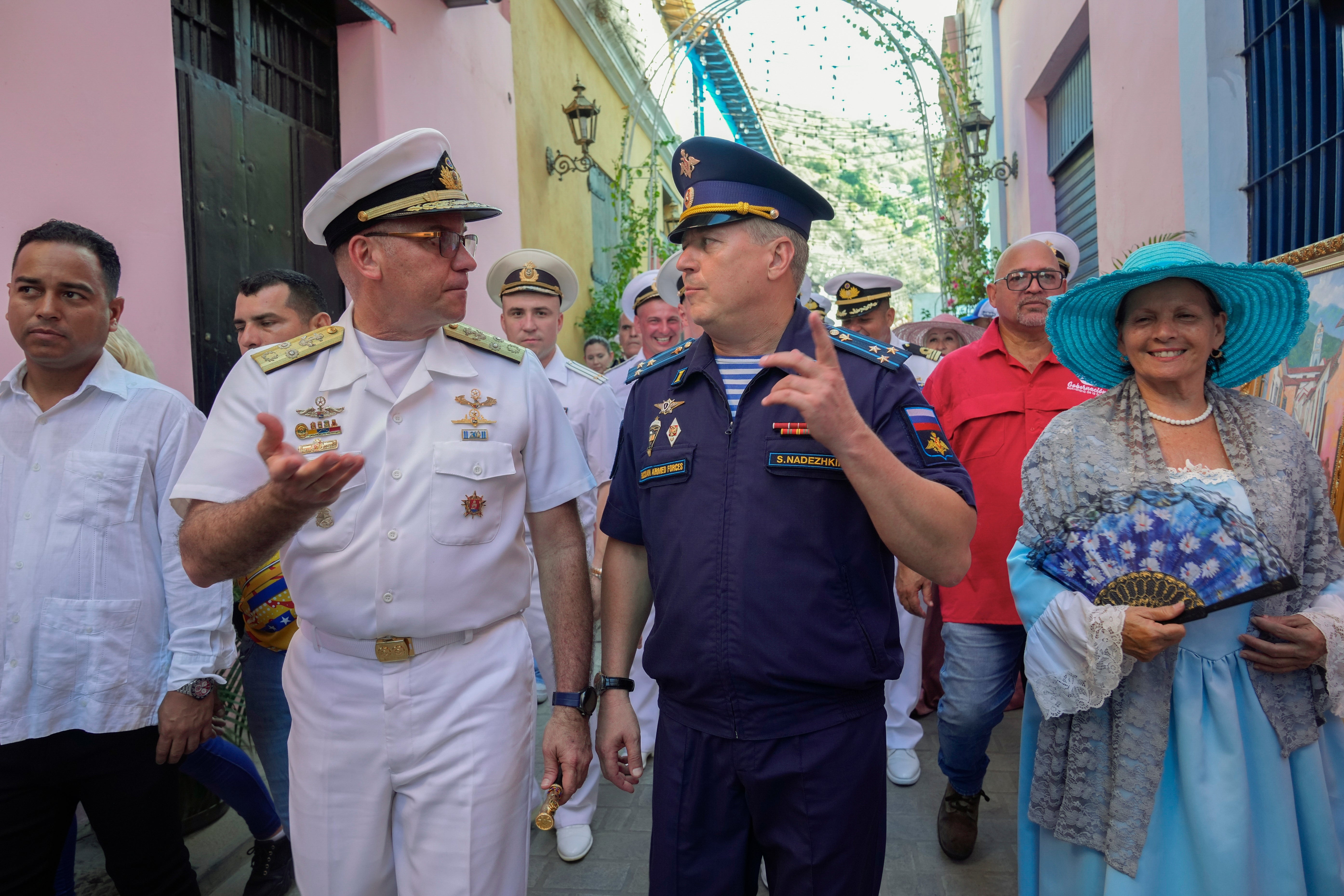Venezuelan Vice Adm. Edward Centeno Mass, left, speaks with a member of the Russian Armed Forces during a welcoming tour