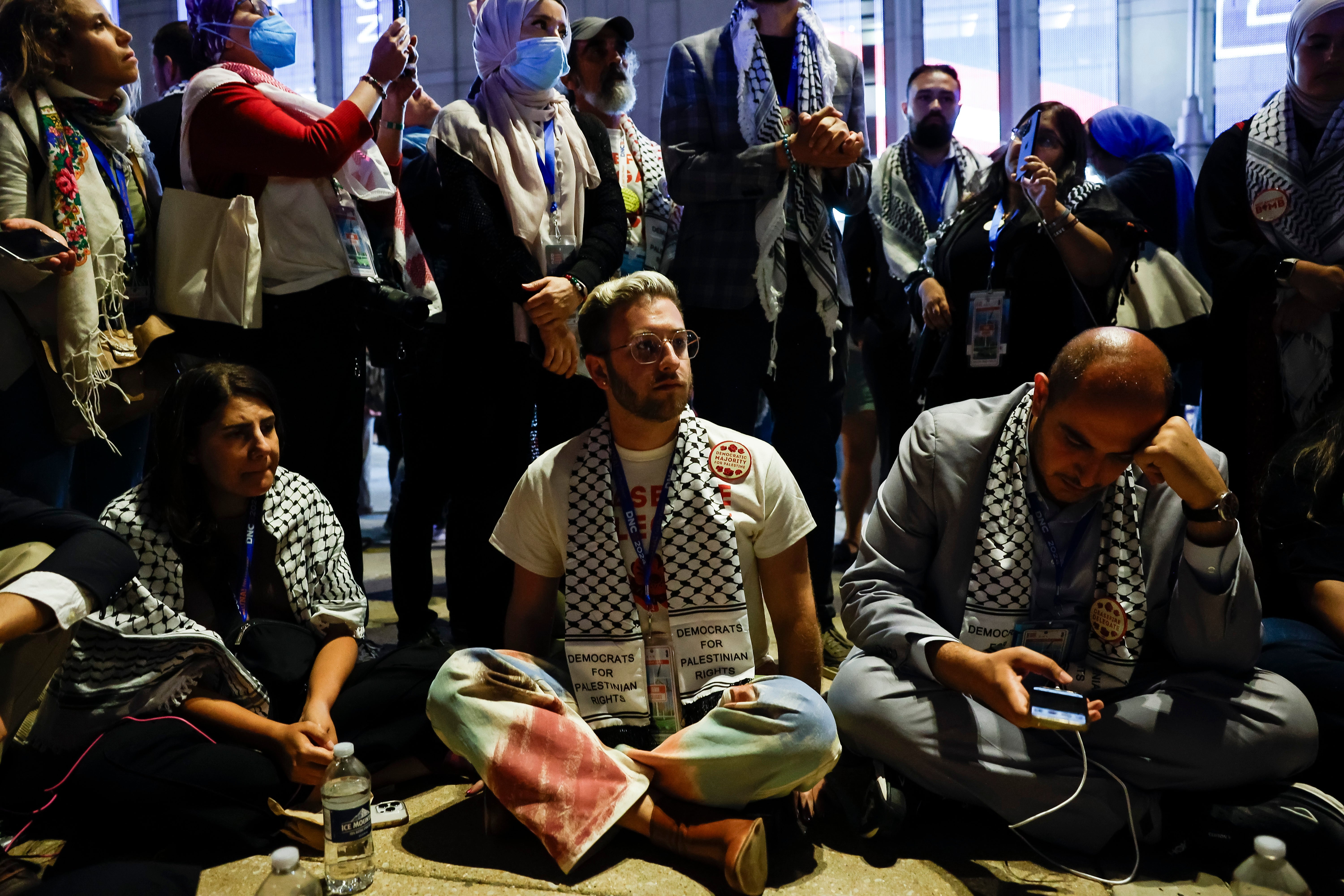 A small group of uncommitted delegates hold a sit-in just outside the United Center to protest the lack of a Palestinian American speaker at the Democratic National Convention