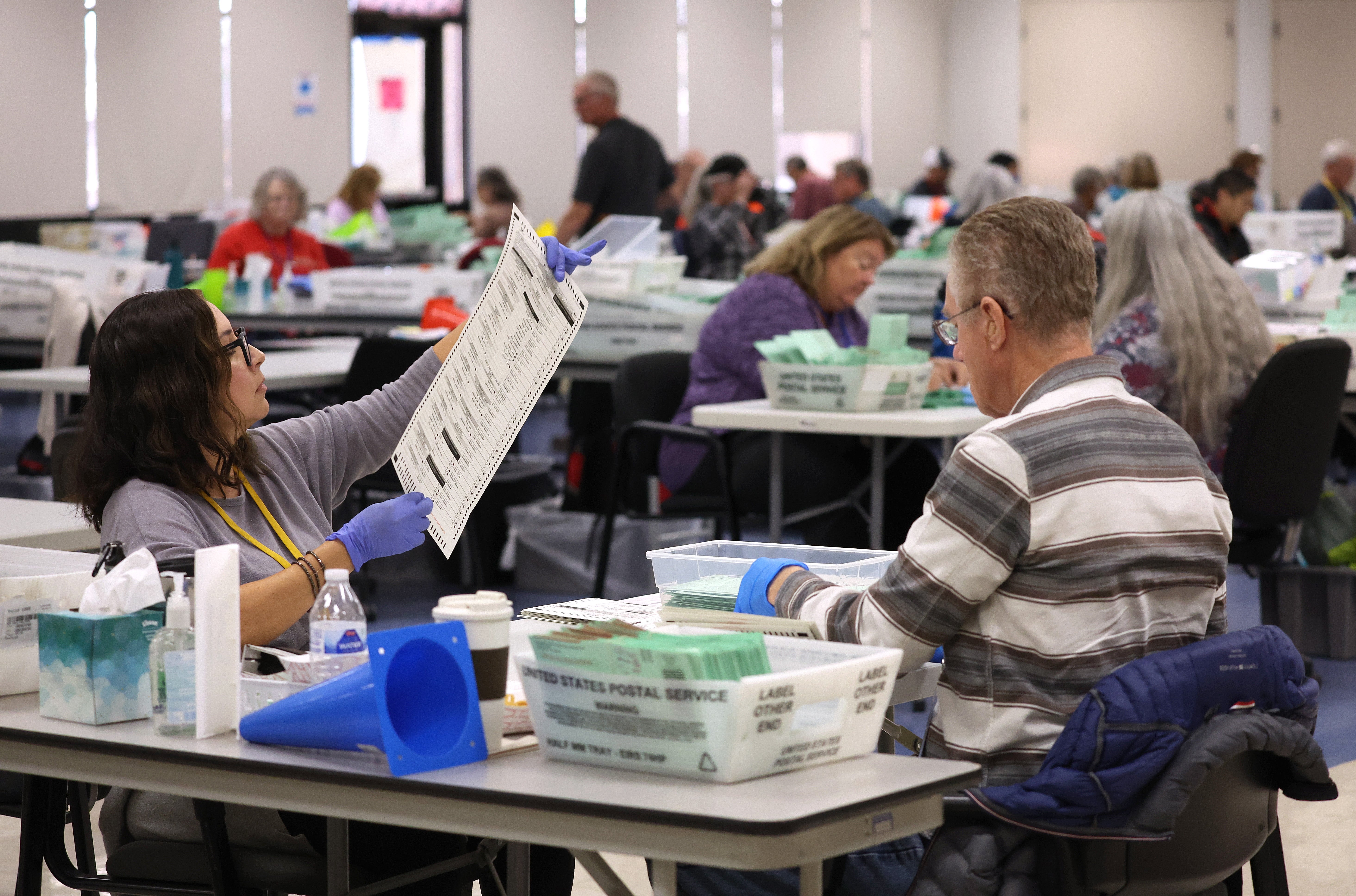 An elections worker inspects a mail-in ballot as she opens up and sorts mail-in ballots prior to tabulation at the Maricopa County Tabulation and Election Center on November 06, 2022. Maricopa Couny was the subject of unsubstantiated claims of voter fraud during the 2020 presidential election