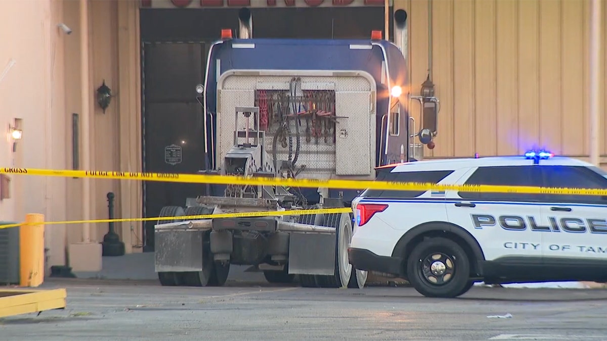 A view of the scene of the crash, with caution tape and a police cruiser present