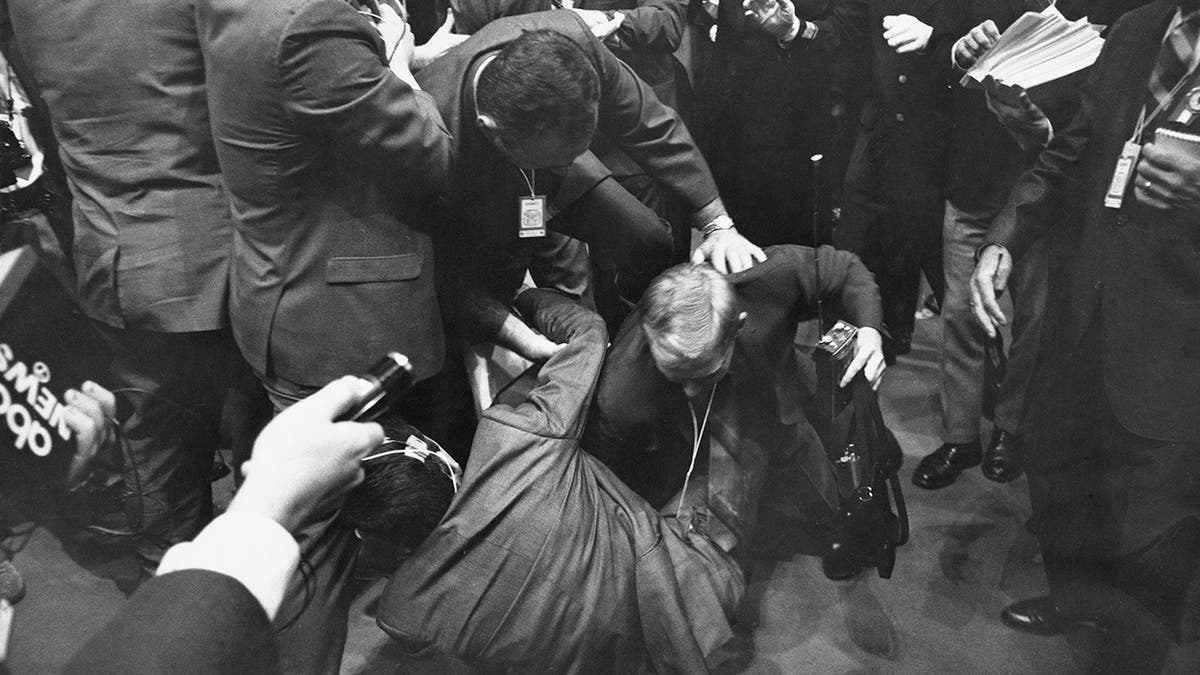 A CBS reporter is thrown to the ground in a scuffle with security staff on the third day of the 1968 Democratic National Convention