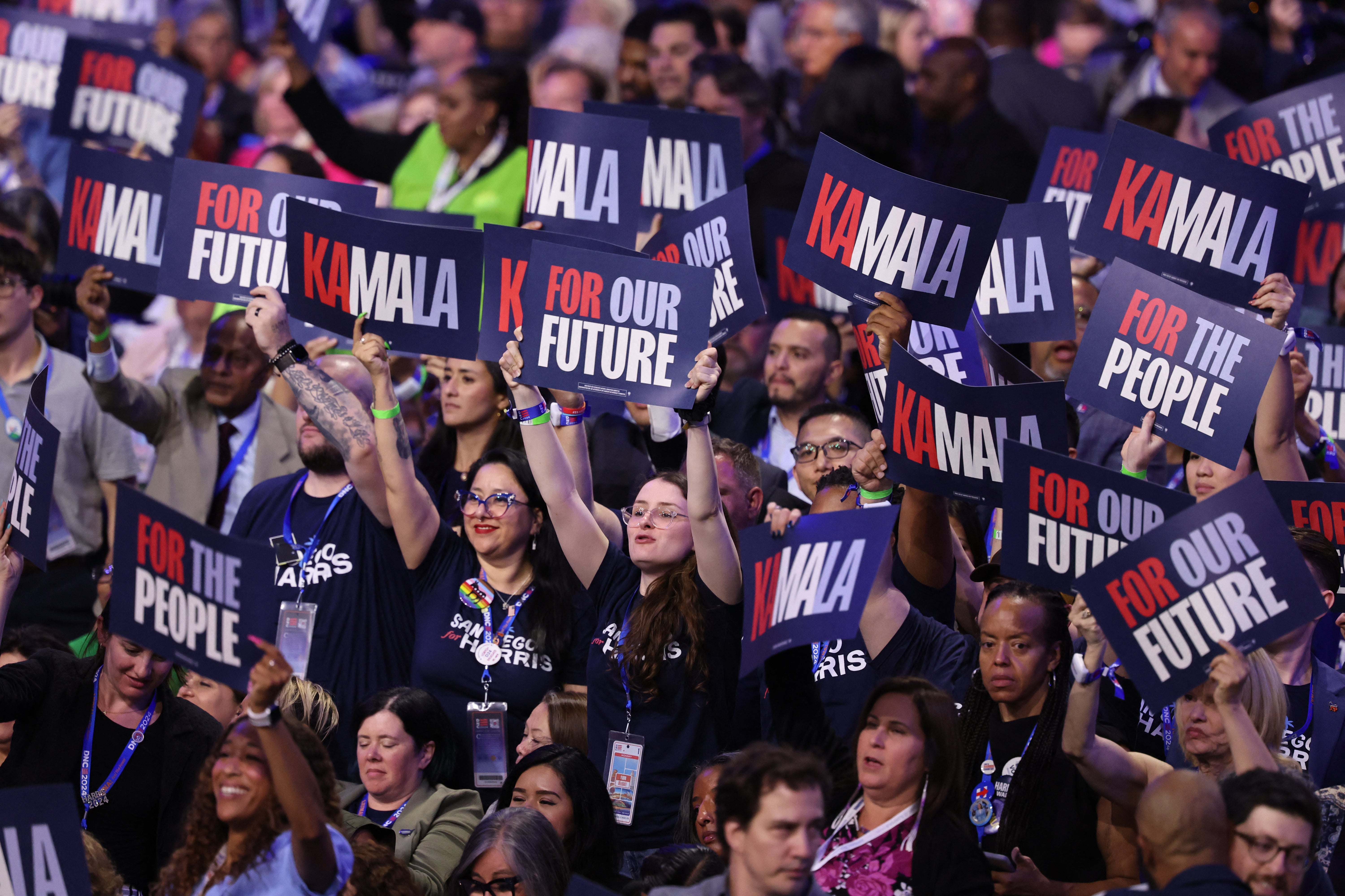 Attendees raise signs in support of Kamala Harris during Day two of the Democratic National Convention