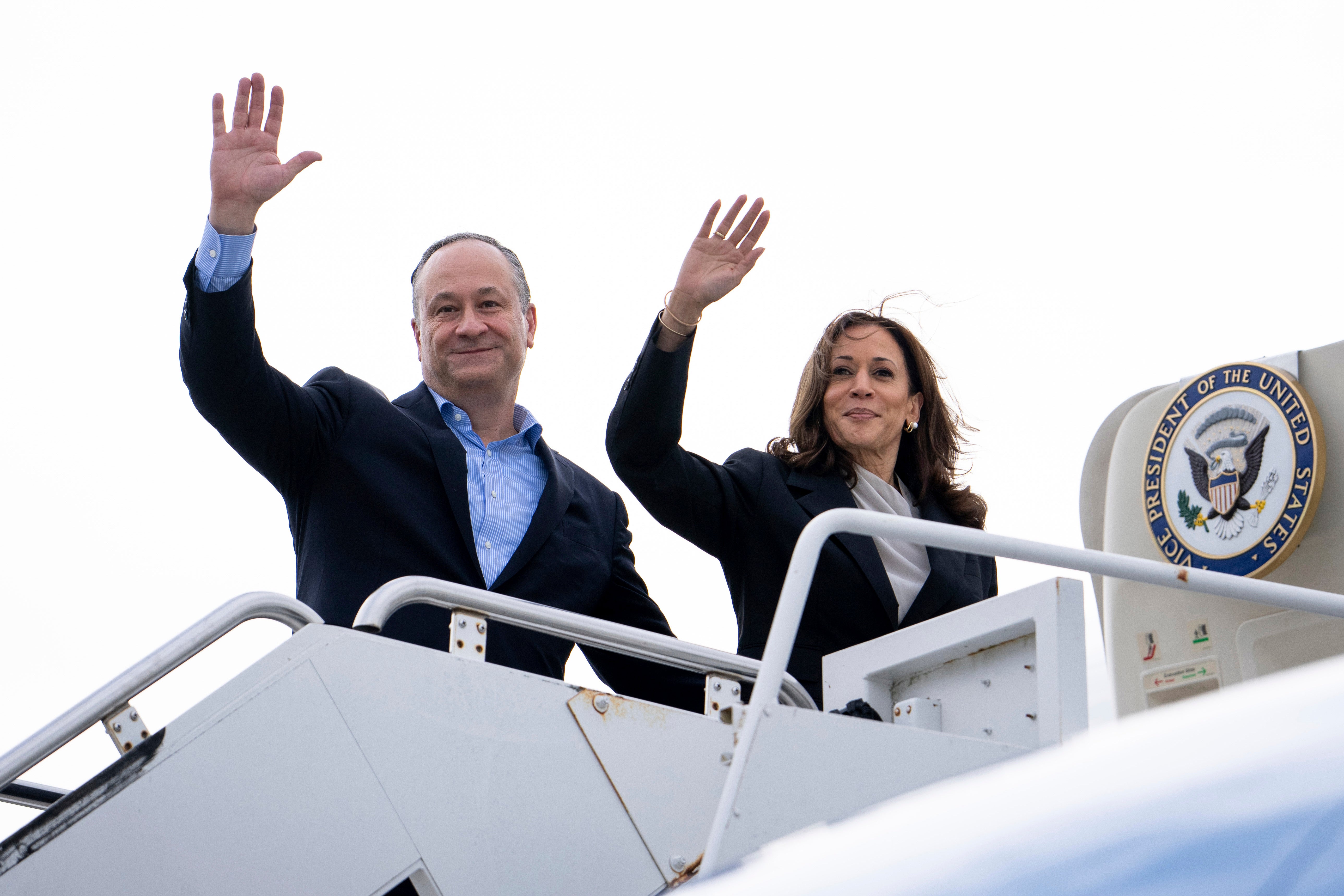 Doug Emhoff and Kamala Harris wave from Air Force Two on the campaign trail in July