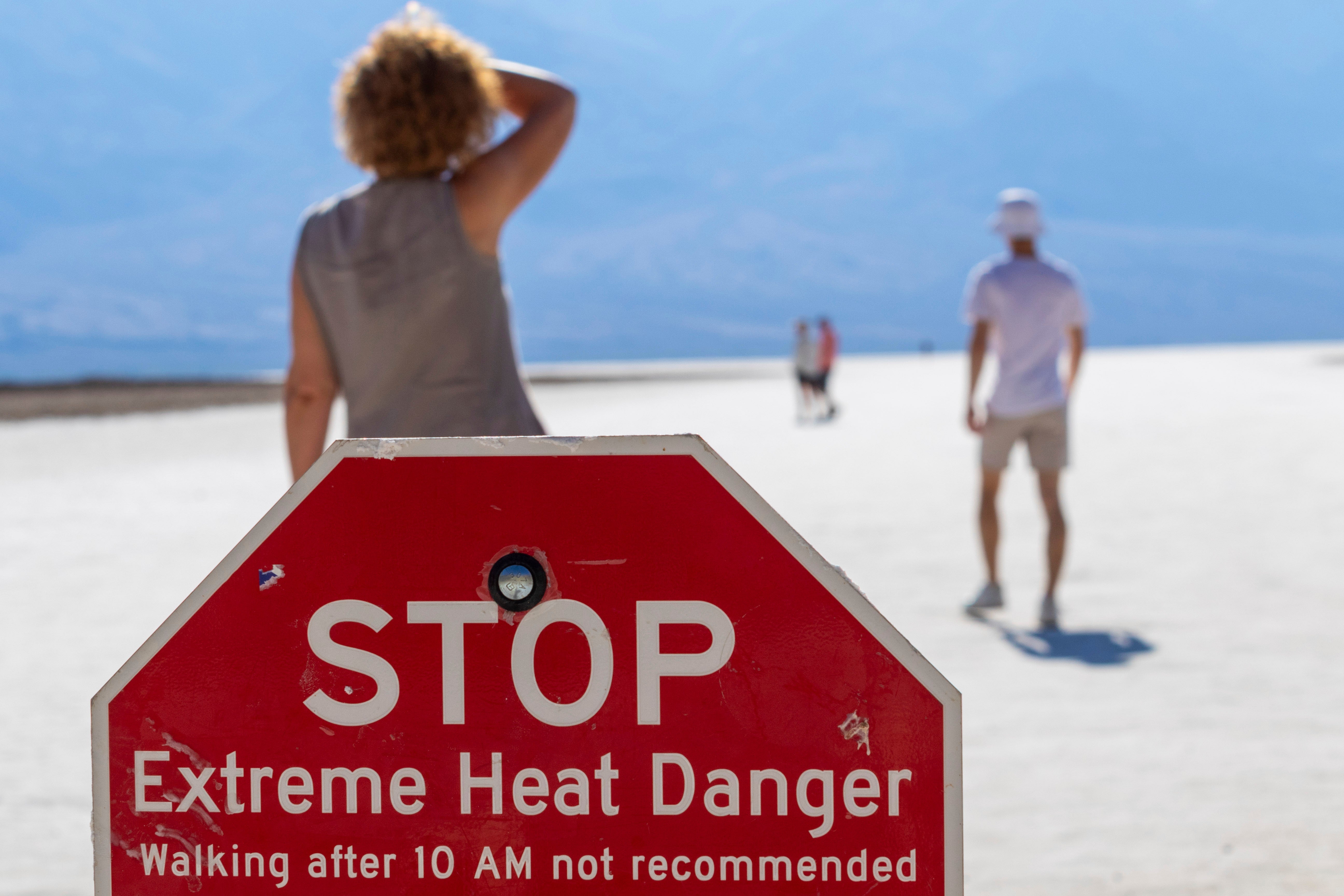 A person wipes sweat from their brow at Badwater Basin in Death Valley National Park