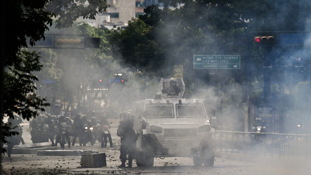 An armoured police car drives through teargas during a protest against Venezuelan President Nicolás Maduro in Caracas on July 29, 2024 a day after the Venezuelan presidential election.