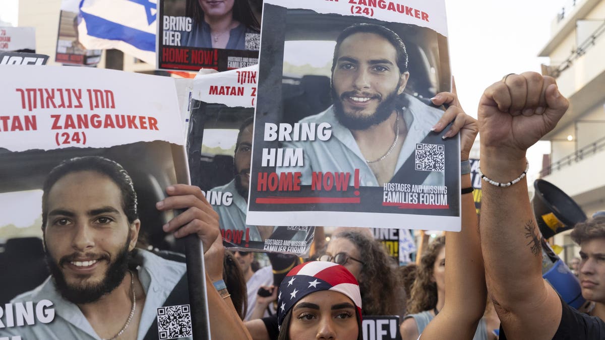 Families of hostages who were kidnaped by Hamas in the Oct. 7 deadly attack and supporters hold signs and U.S. flags during a demonstration outside a press event by U.S. Secretary of State Antony Blinken on August 19, 2024, in Tel Aviv, Israel. 