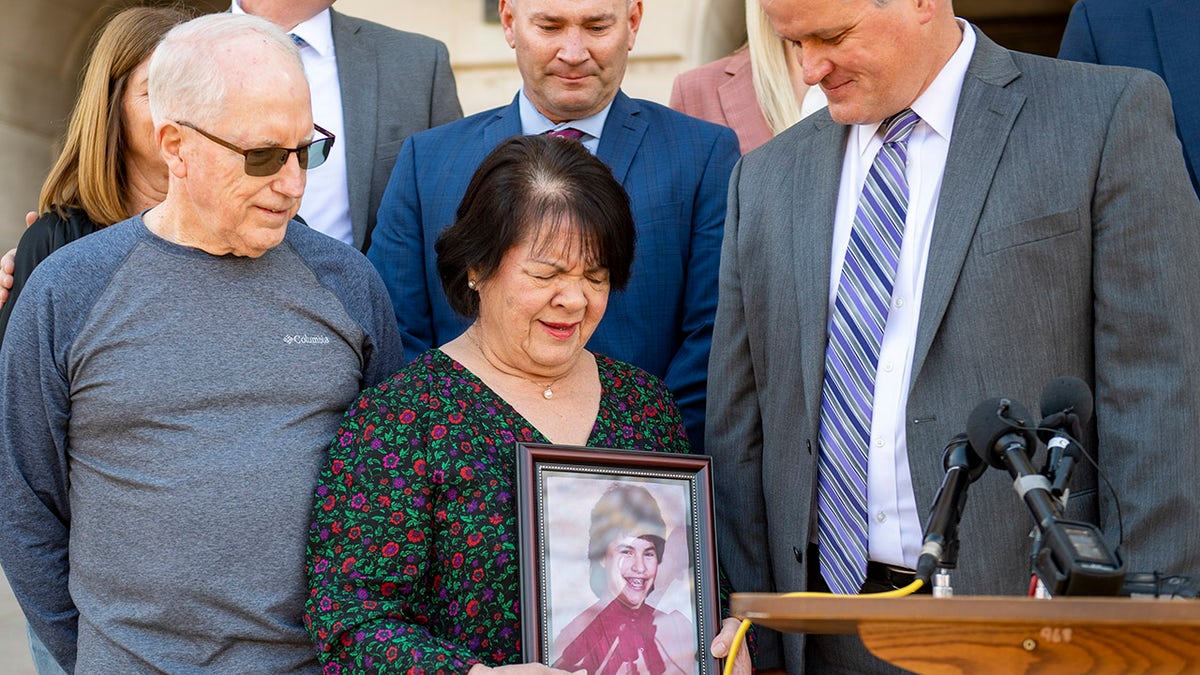 Jonelle Matthews parents grieving with a photo of their daughter.