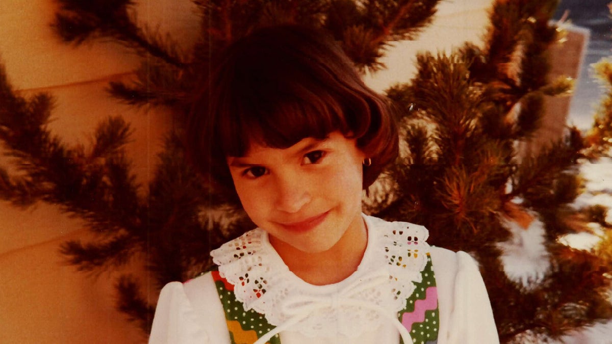 Jonelle Matthews wearing a white dress smiling at the camera.