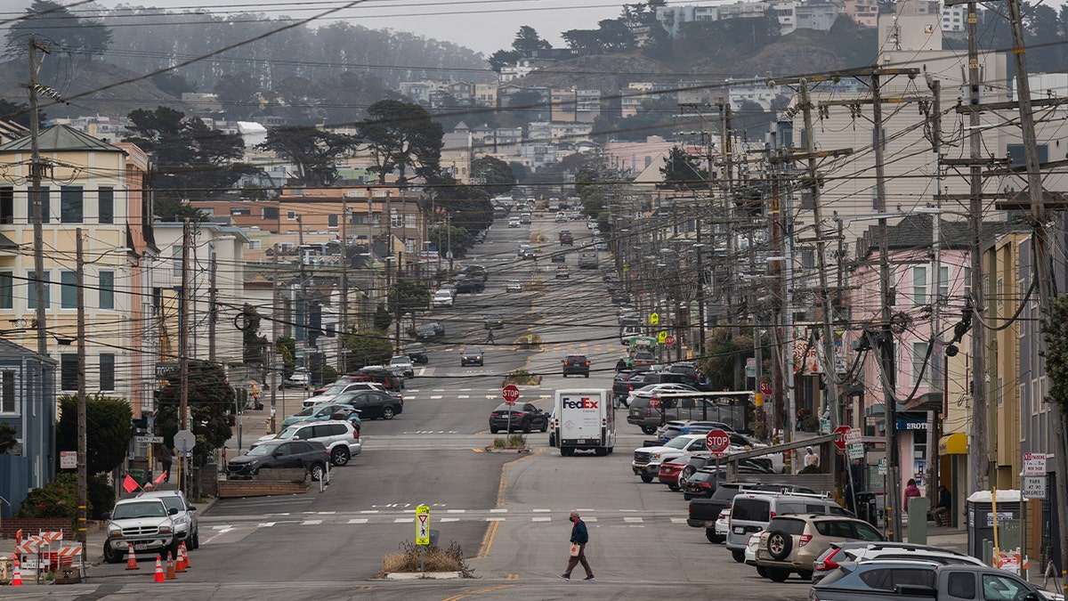 A pedestrian crosses a street in the Outer Sunset district by Ocean Beach on June 26, 2023 in San Francisco.