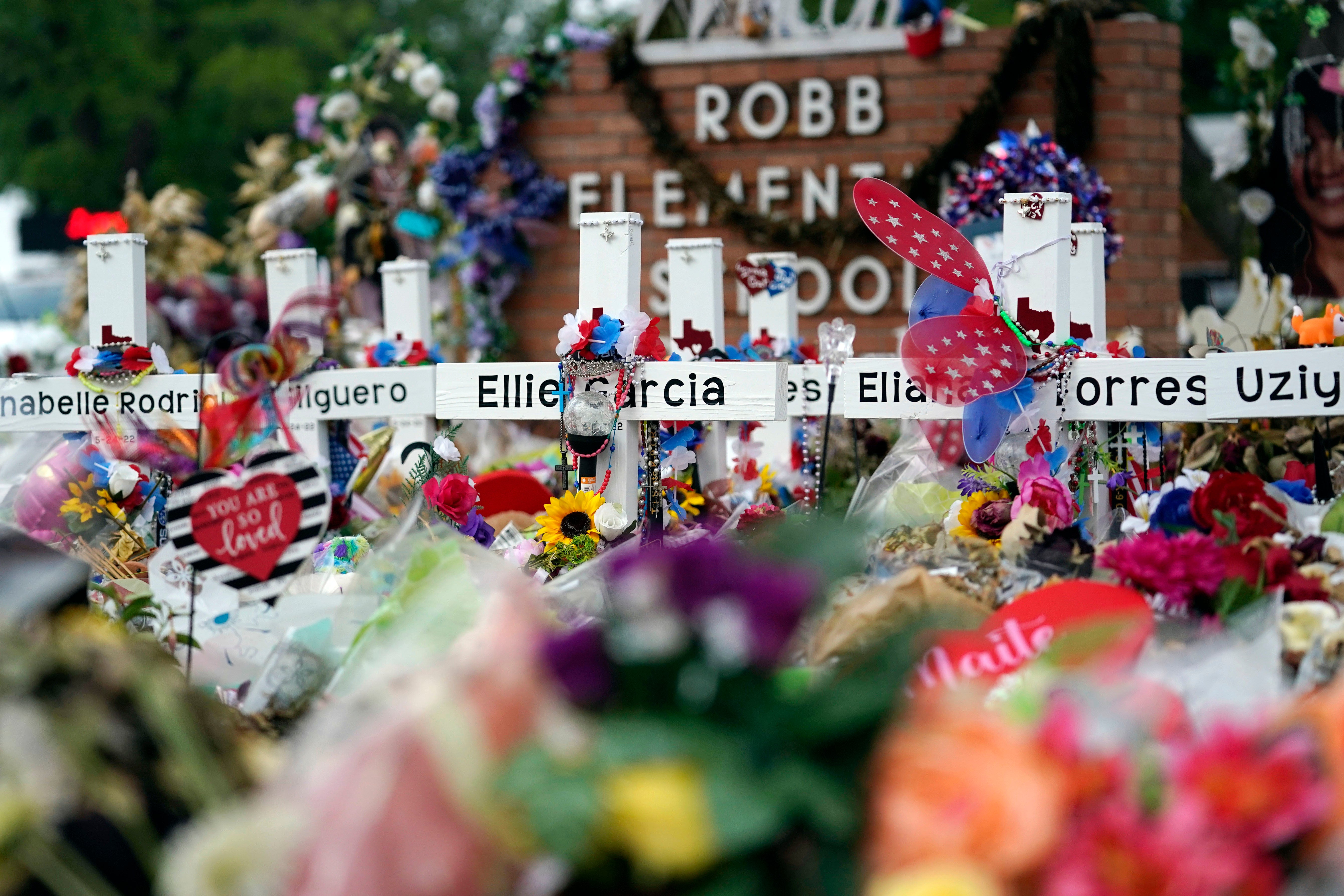 Flowers and other items surround crosses at a memorial on June 9, 2022, for the victims of a shooting at Robb Elementary School in Uvalde, Texas. Newly released info shows frantic 911 calls during the shooting.