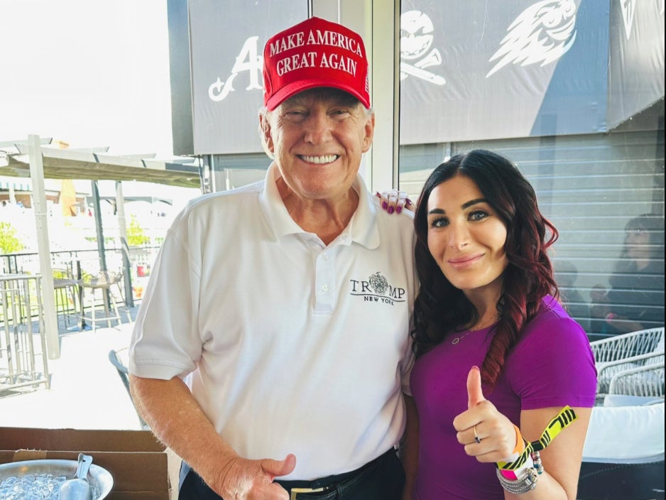 Donald Trump and Laura Loomer pose at LIV golf event in August 2023. She promoted a dog food from a company that promotes many MAGA ideals