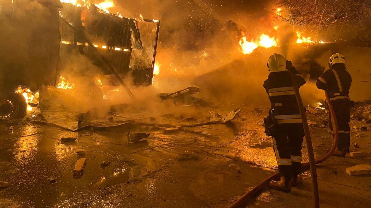 Firefighters extinguish fire in trucks at a site where warehouse facilities were hit during a Russian drone strike, amid Russia's attack on Ukraine, in the village of Murovane, outside of Lviv, Ukraine September 6, 2024. 