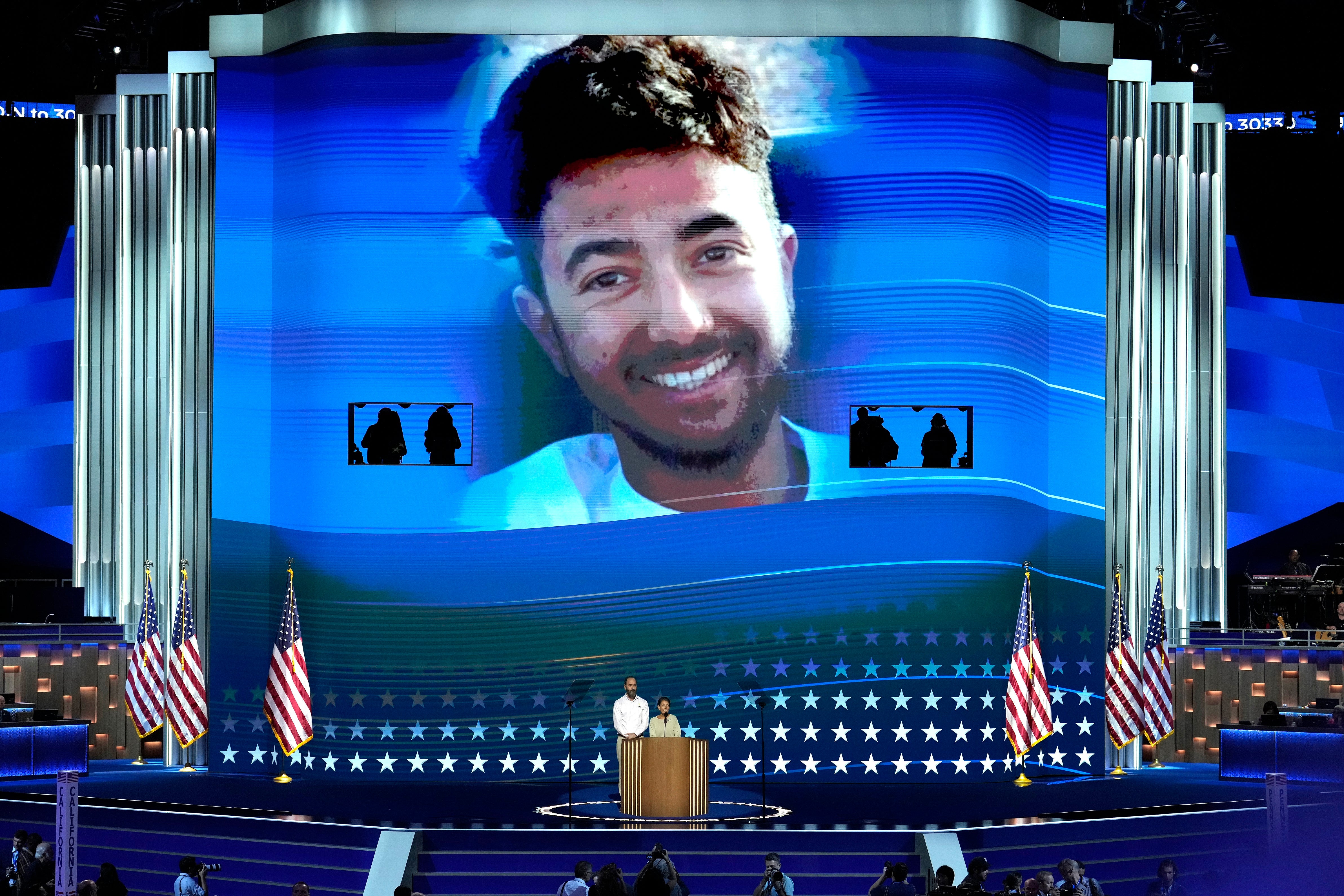 Jon Polin, left, and Rachel Goldberg, parents of Hersh Goldberg-Polin, pictured on screen speak during the Democratic National Convention Wednesday, 21 Aug 2024, in Chicago