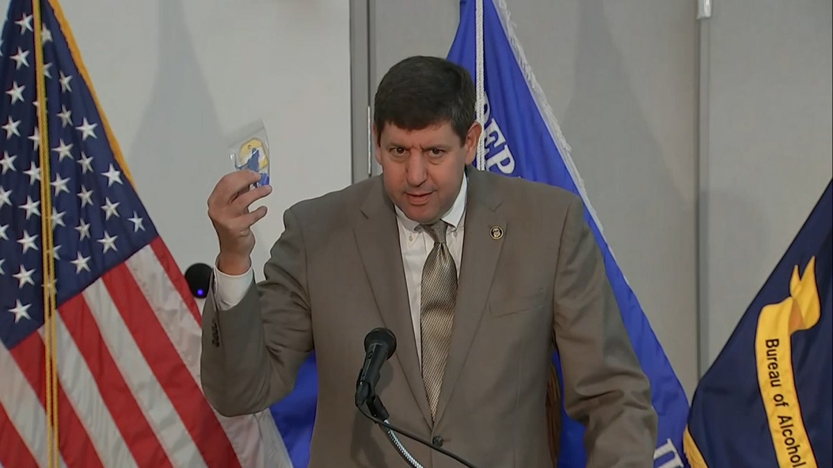 ATF Director Steve Dettlebach holds up a machine gun conversion device.