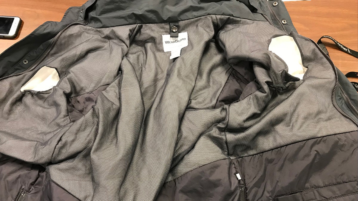 The inside of a jacket with holes cut into the lining to hide cocaine