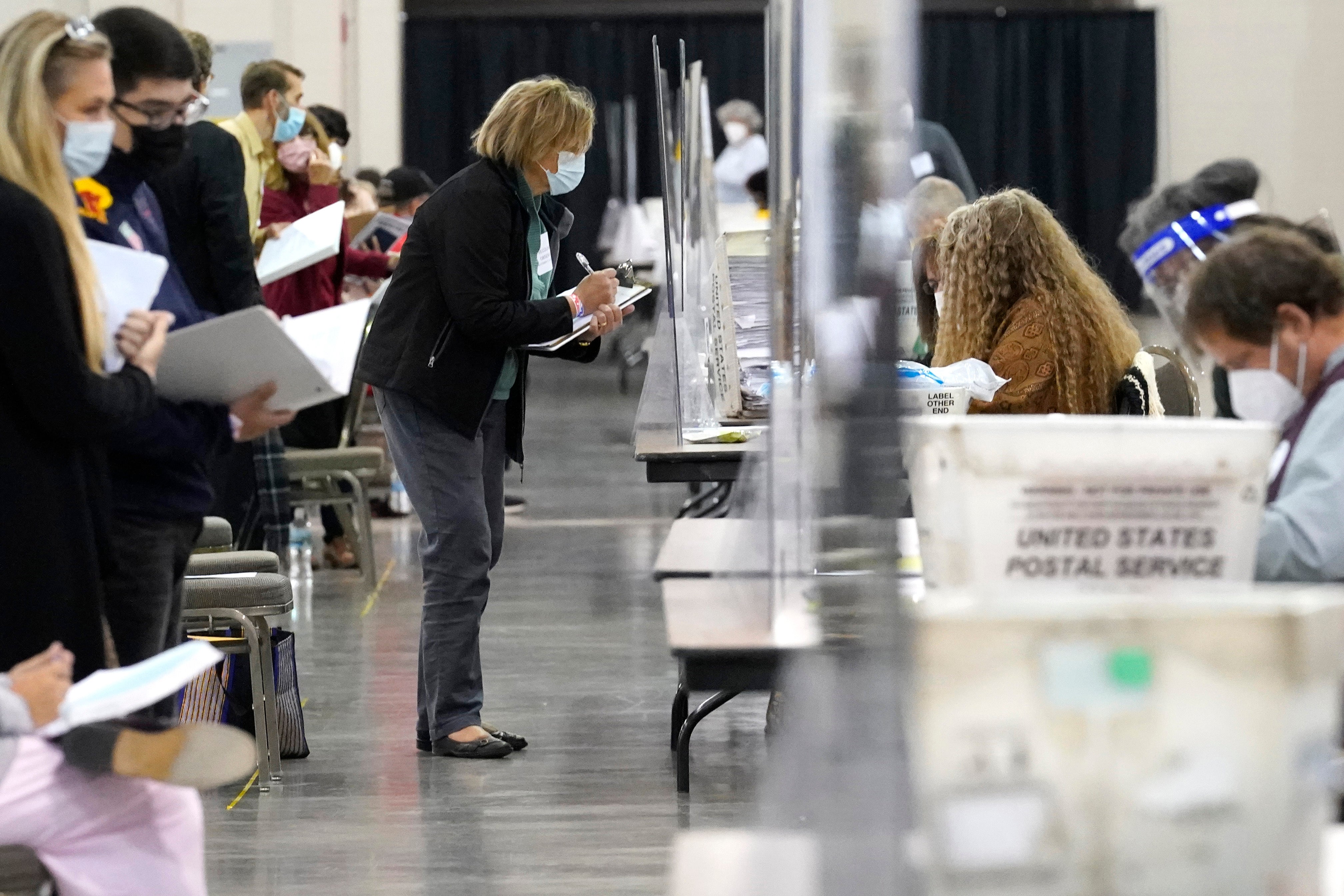 Recount observers watch ballots during a Milwaukee hand recount of Presidential votes at the Wisconsin Center, Nov. 20, 2020, in Milwaukee, Wisconsin. Counties across the country are implementing new measures to promote transparency ahead of the 2024 presidential election