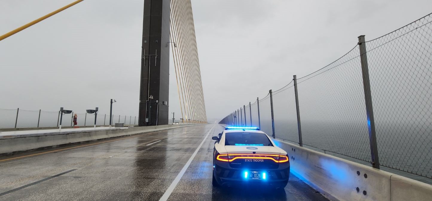 A state trooper sits on the Sunshine Skyway Bridge, which was closed Thursday