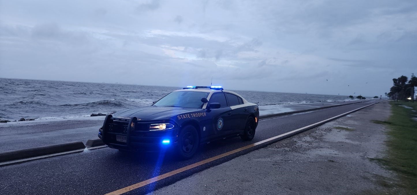 A state trooper sits by the Sunshine Skyway Bridge, as weather conditions there deteriorate