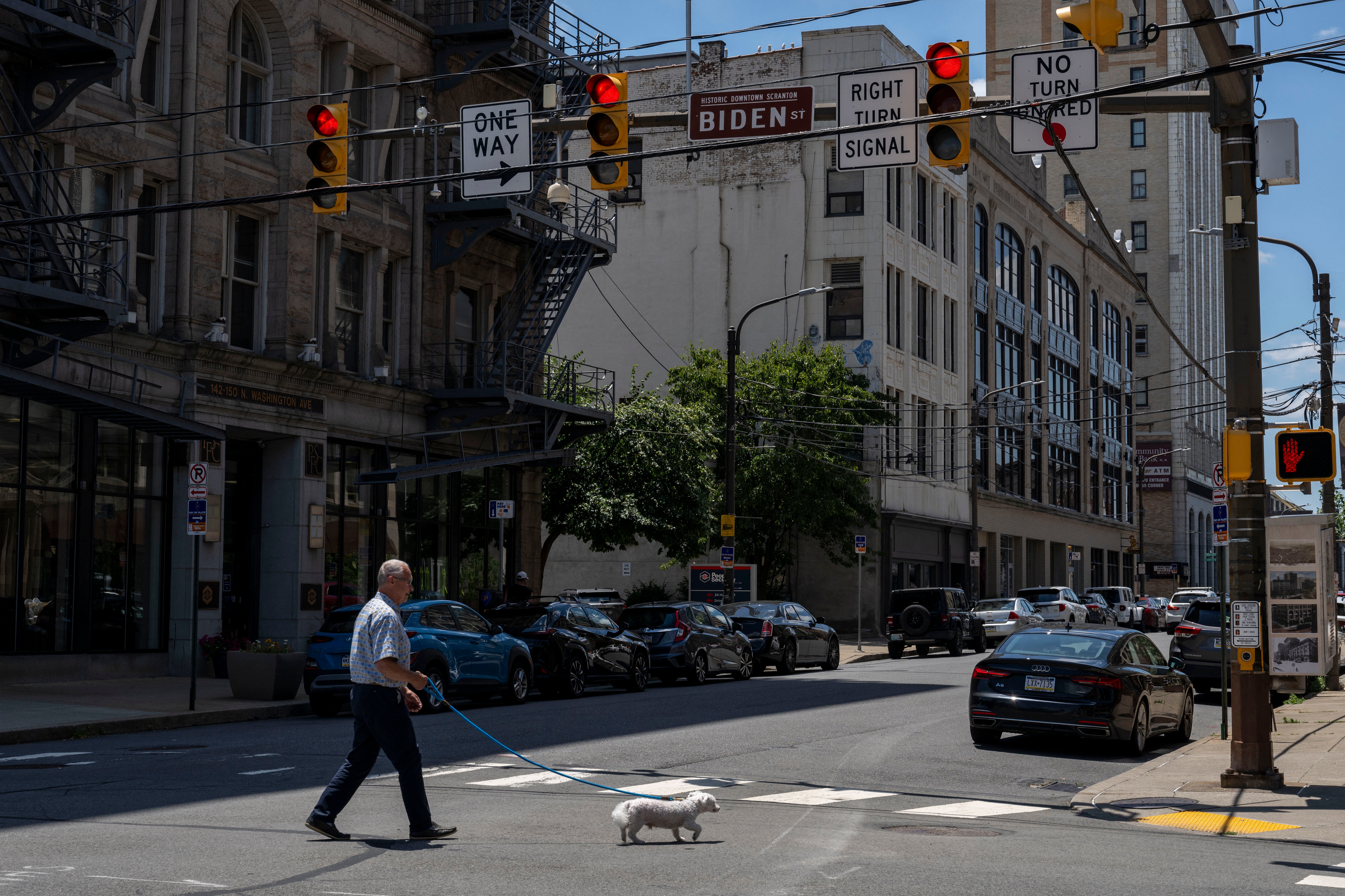 A man walks his dog in downtown Scranton, Pennsylvania on July 3, 2024