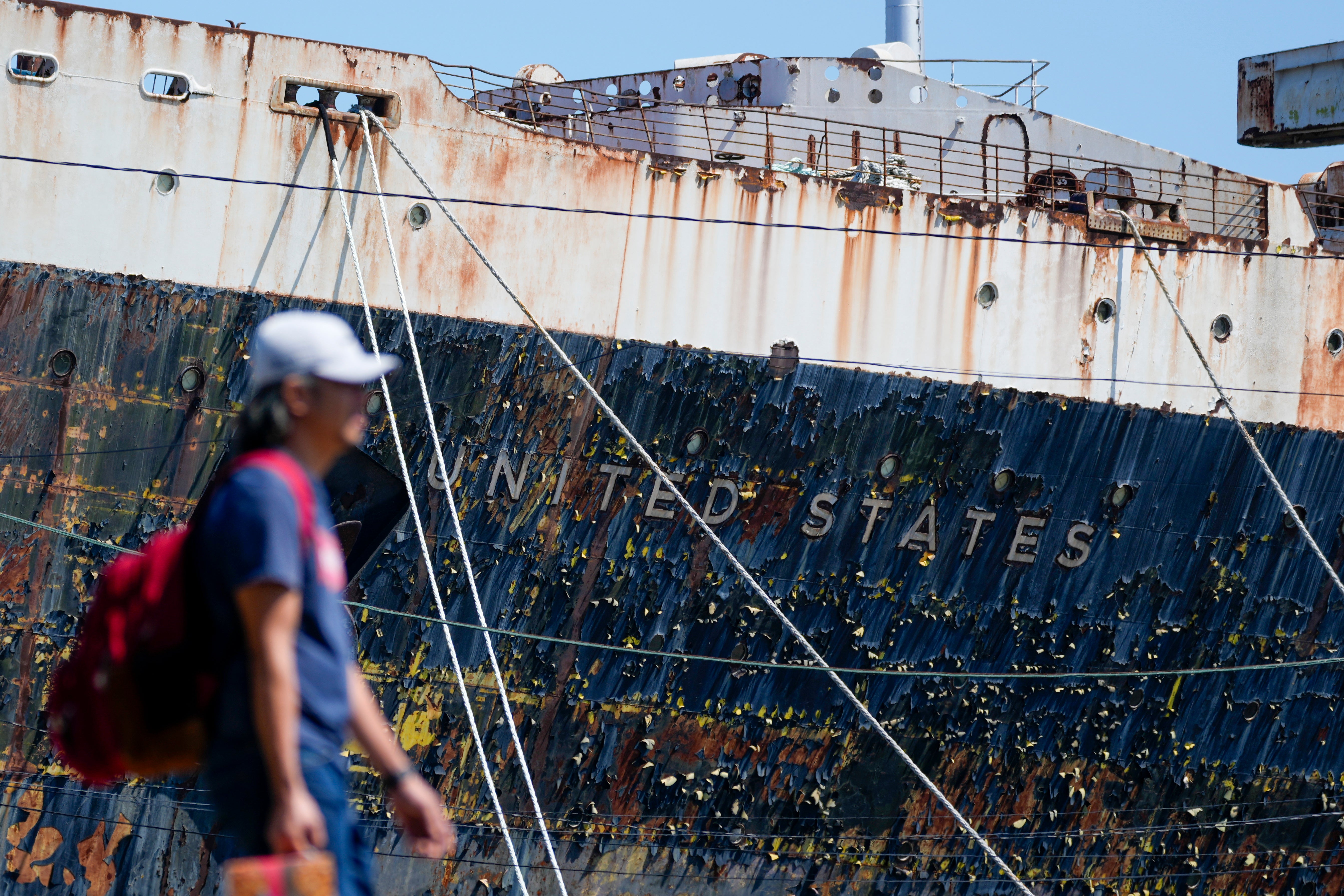 A person walks past the S.S. United States moored on the Delaware River in Philadelphia,