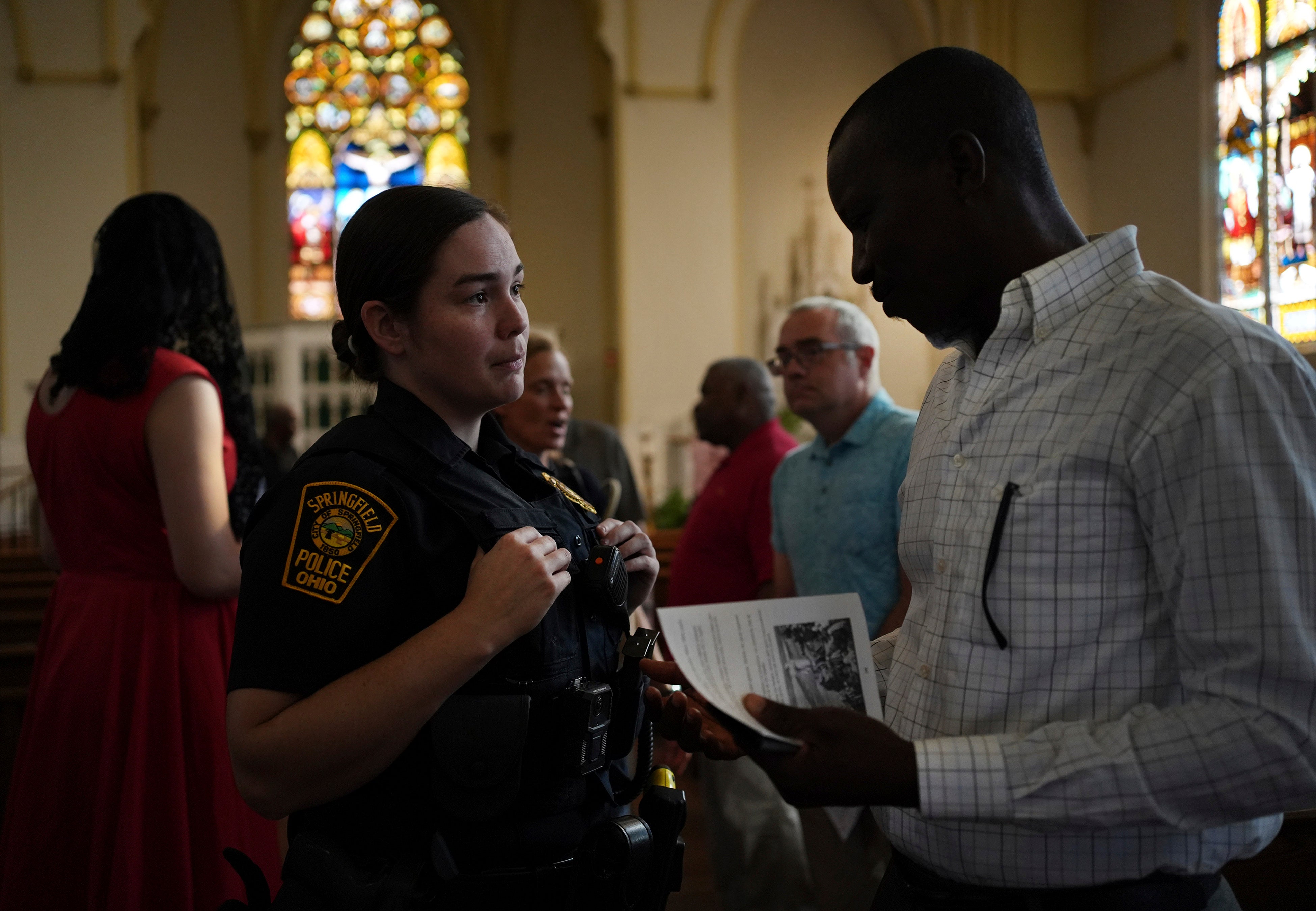 A Springfield police officer talks to a parishioner after a service in support of the Haitian community at St Raphael Catholic church in Springfield on September 15