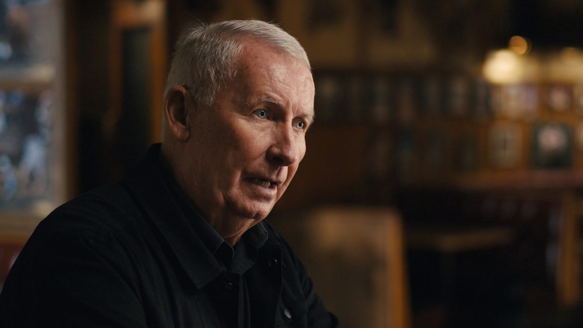 Detective Gary Deckard speaking and wearing black.