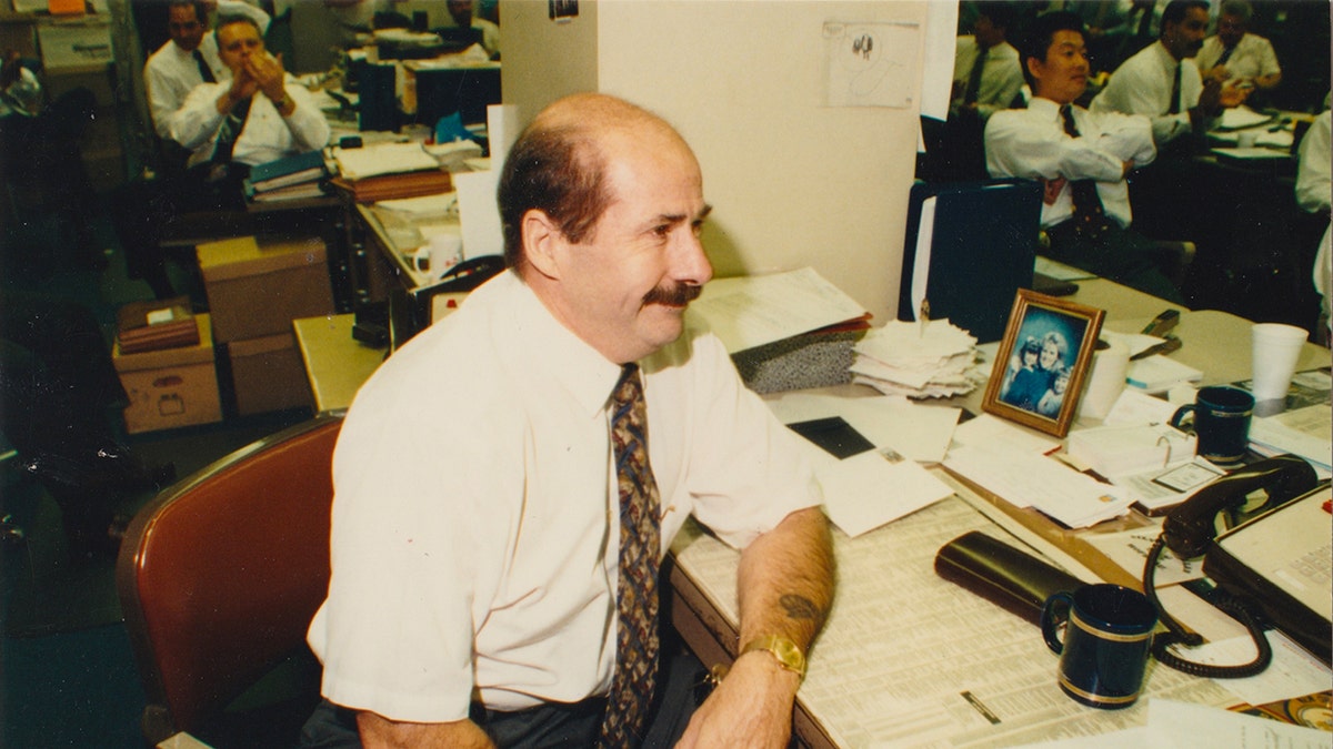 Tom Lange sitting at his desk looking away.