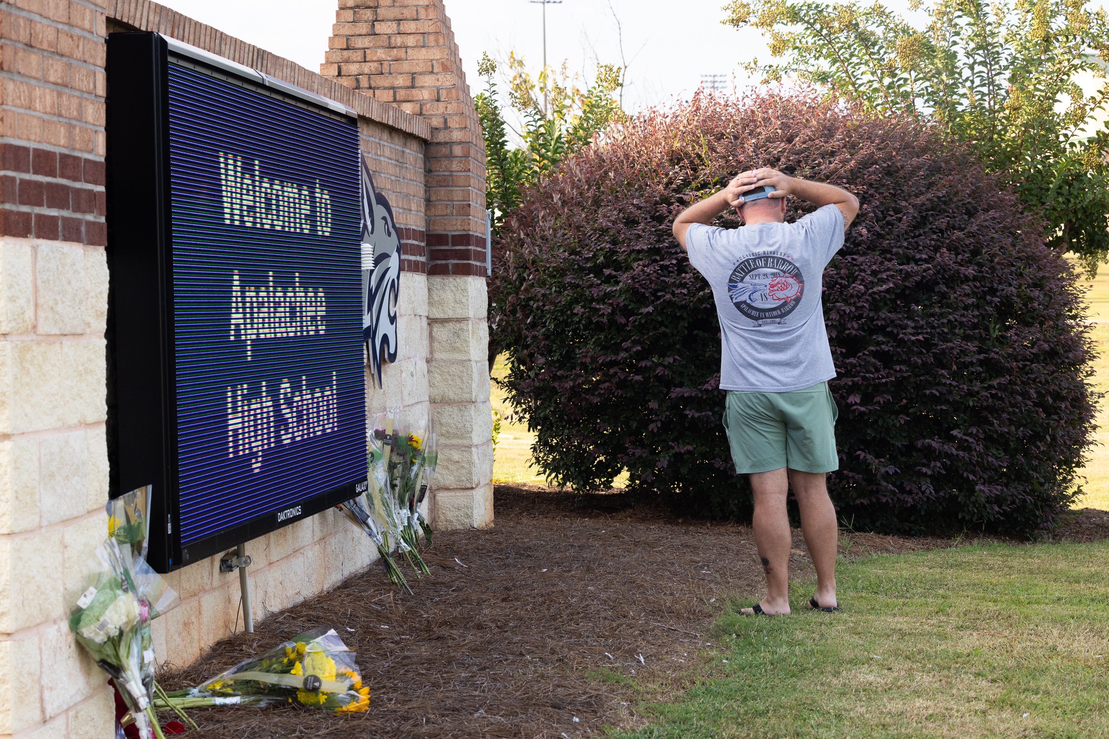 A man stands near a vigil at Apalachee High School. Gray has been charged with four counts of felony murder following Wednesday’s shooting