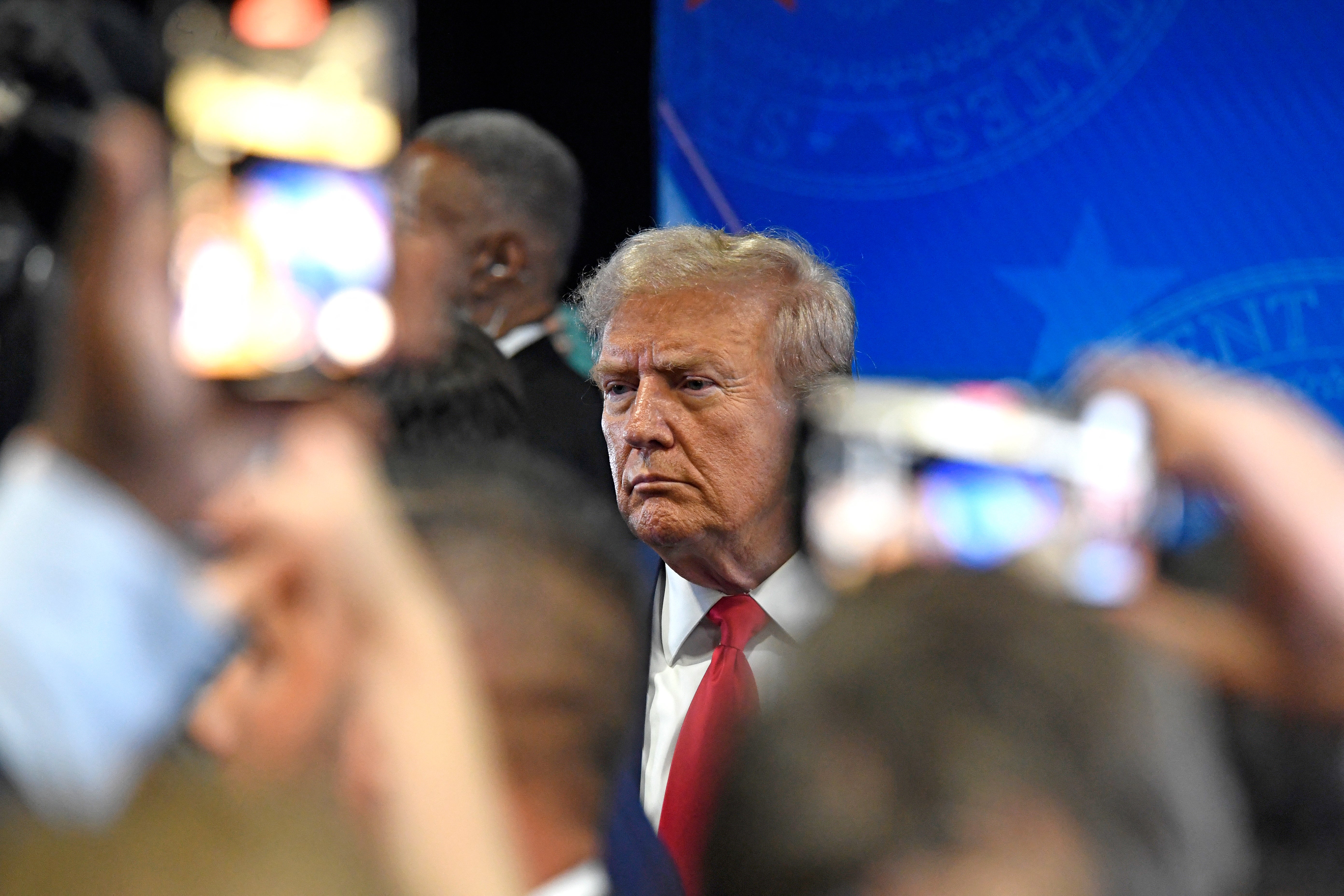 Former US President and Republican presidential candidate Donald Trump speaks to members of the press in the spin room following a presidential debate with US Vice President and Democratic presidential candidate Kamala Harris