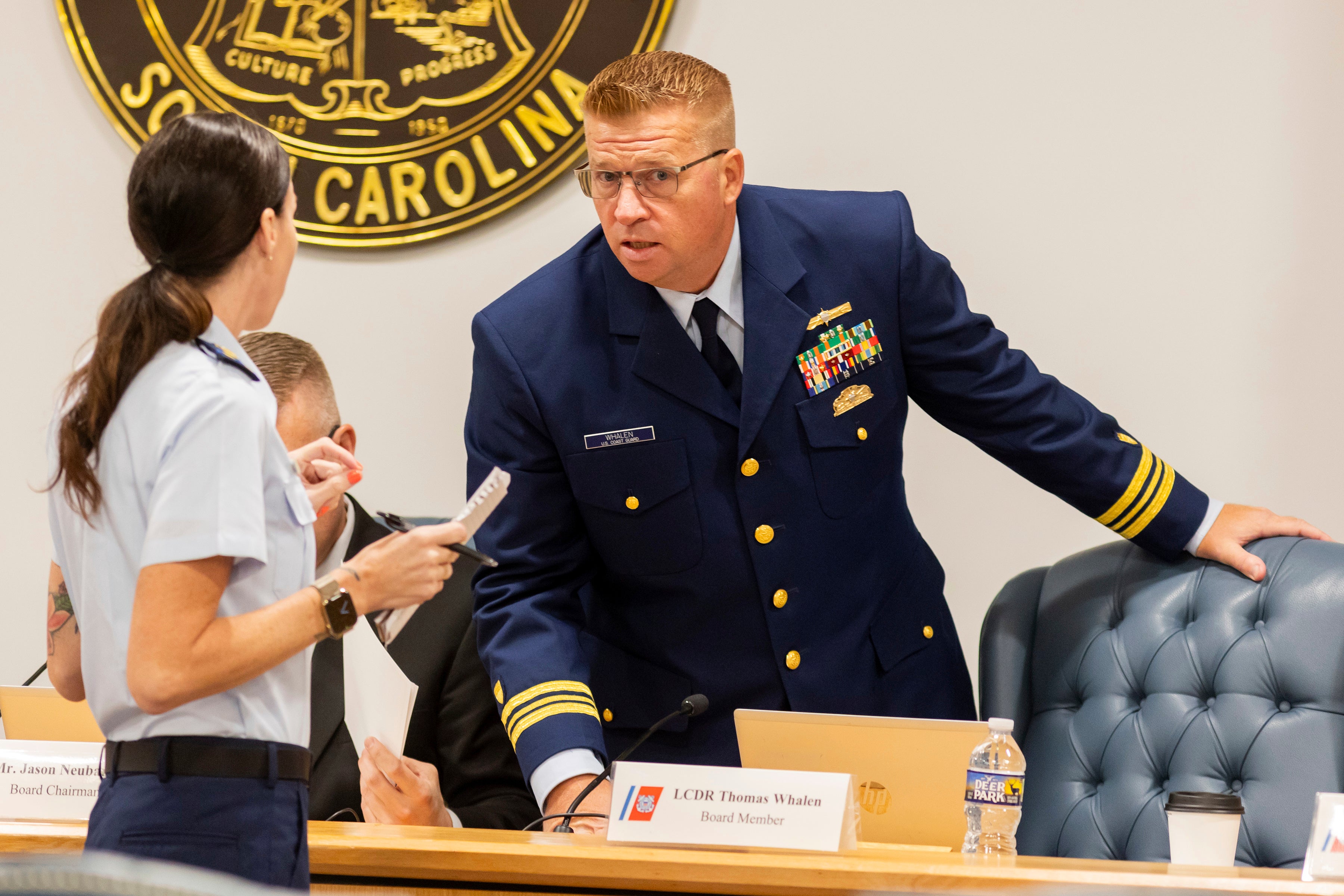 Coast Guard’s Thomas Whalen speaks with another Coast Guard member during a break for the Titan marine board formal hearing