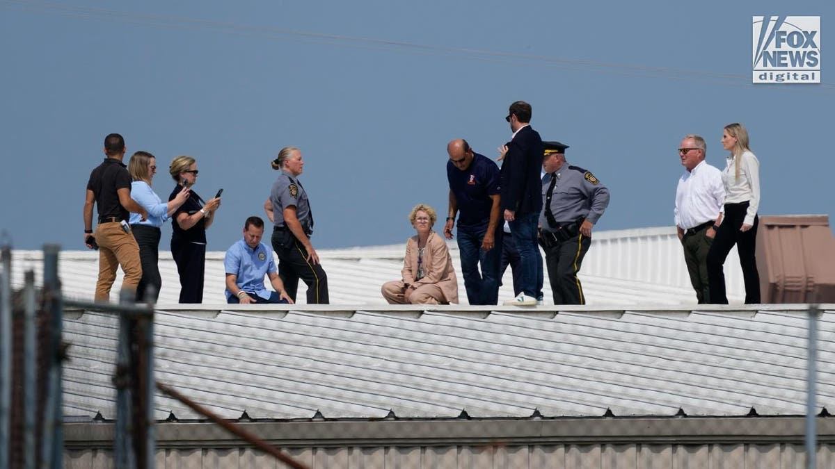 Trump assassination attempt task force members stand on the roof of the building where the shooter was positioned