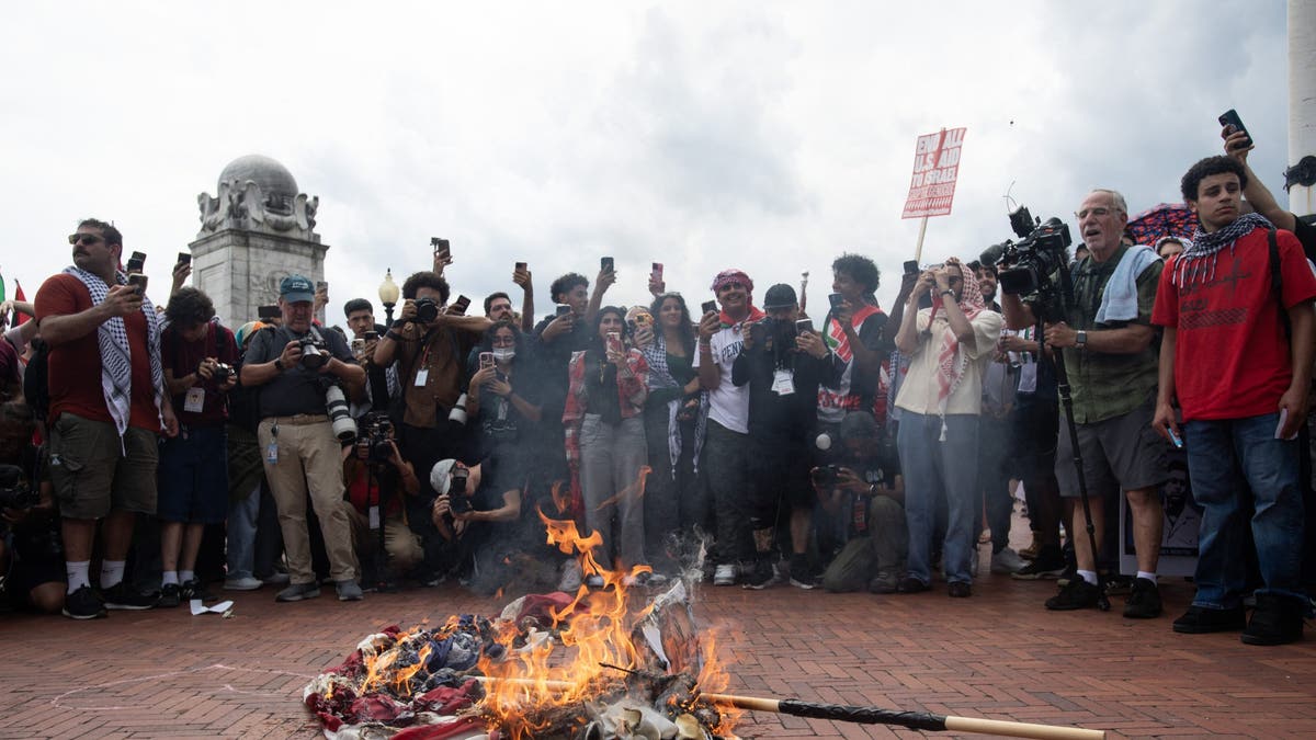 US flag burning on the ground 