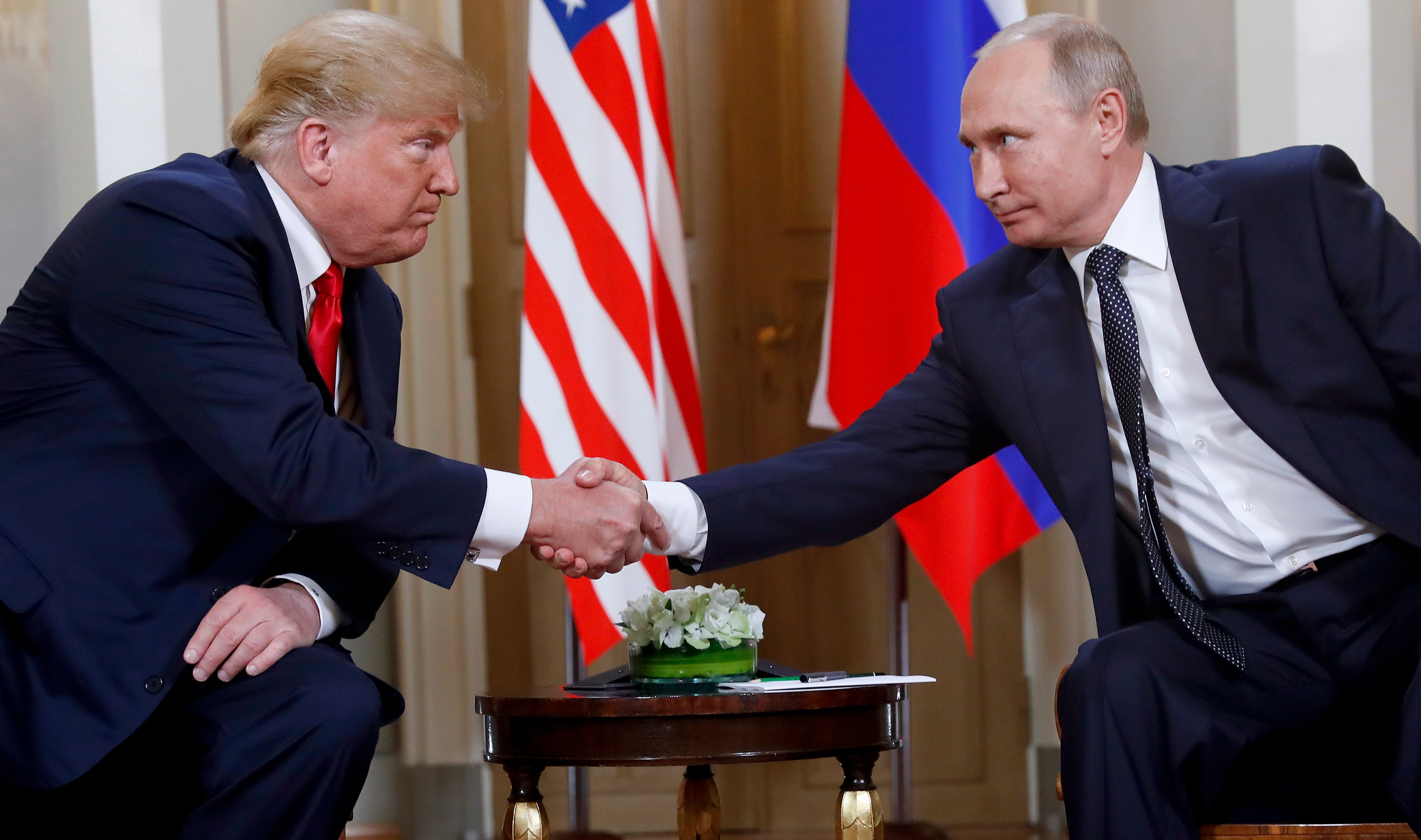 President Donald Trump, left, and Russian President Vladimir Putin shake hands at the beginning of a meeting at the Presidential Palace in Helsinki, Finland, July 16, 2018.