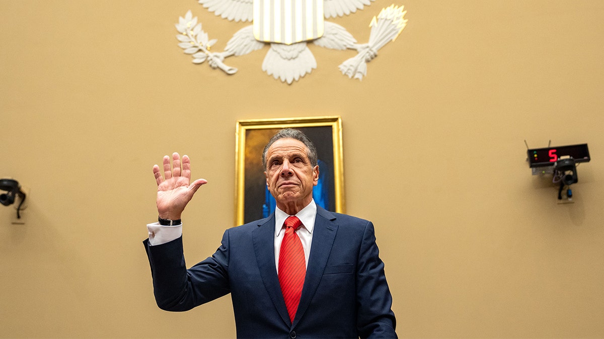 Andrew Cuomo with his hand in the air