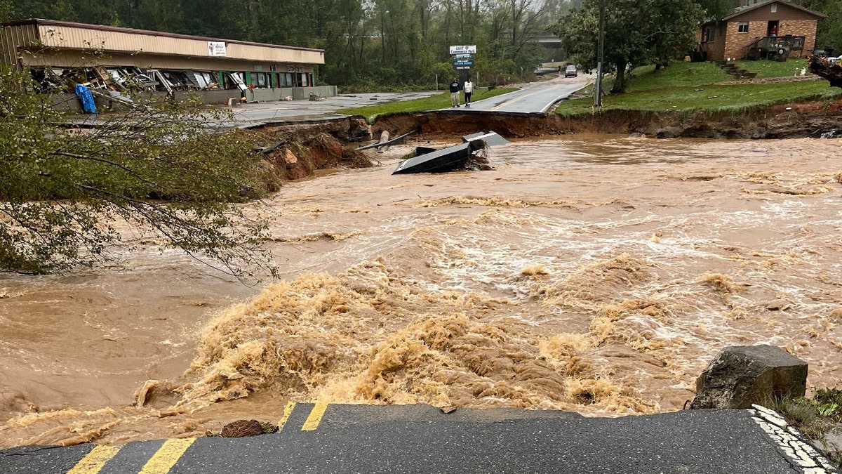 A river cuts through an asphalt road in Black Mountain, North Carolina.