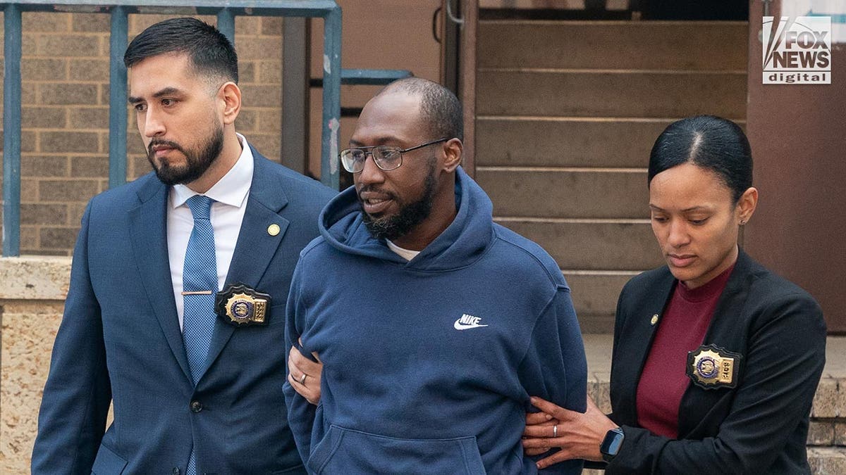 Man accused of assault on former Governor Paterson is in handcuffs as she is walked by police.