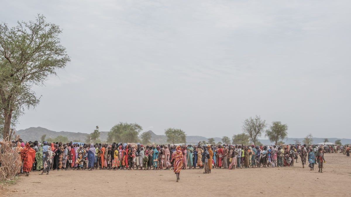 Hundreds of people line up to register for a potential food aid delivery at the Agiri internal displacement camp, in April 2023. 