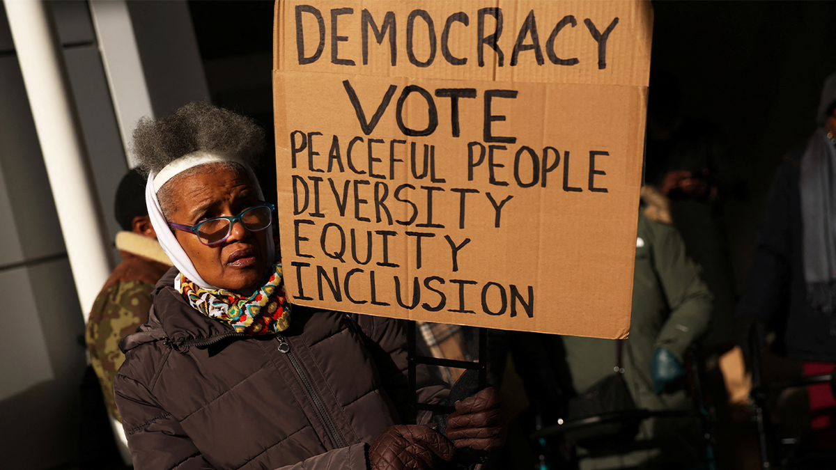 WOMAN HOLDS DEI SIGN AT NYC PROTEST