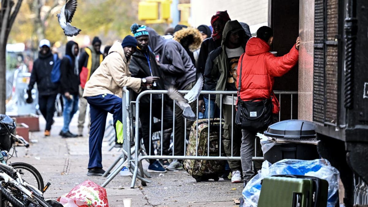 Migrants line up in front of the East Village re-intake, converted into a city-run shelter for newly arrived migrant families in New York City, on Dec. 4, 2023.