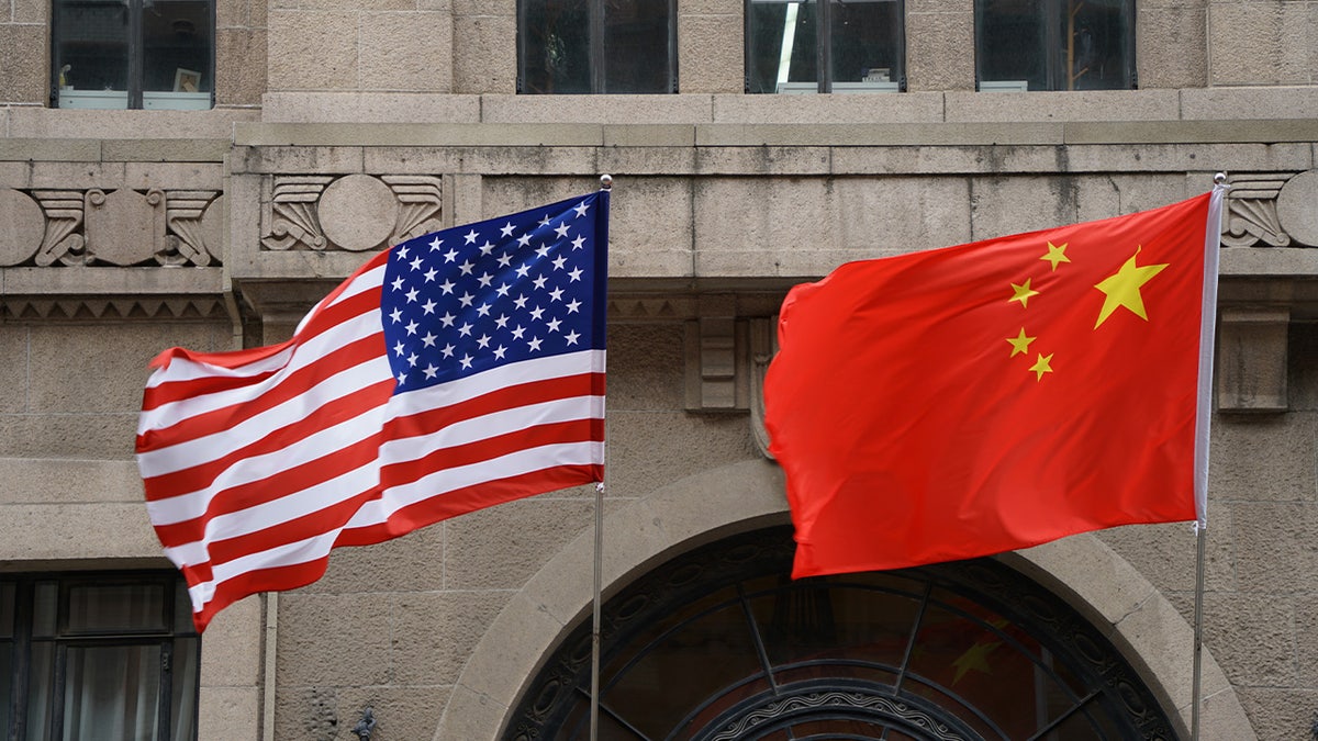 The national flags of the United States and China flutter at the Fairmont Peace Hotel on April 25, 2024, in Shanghai, China.