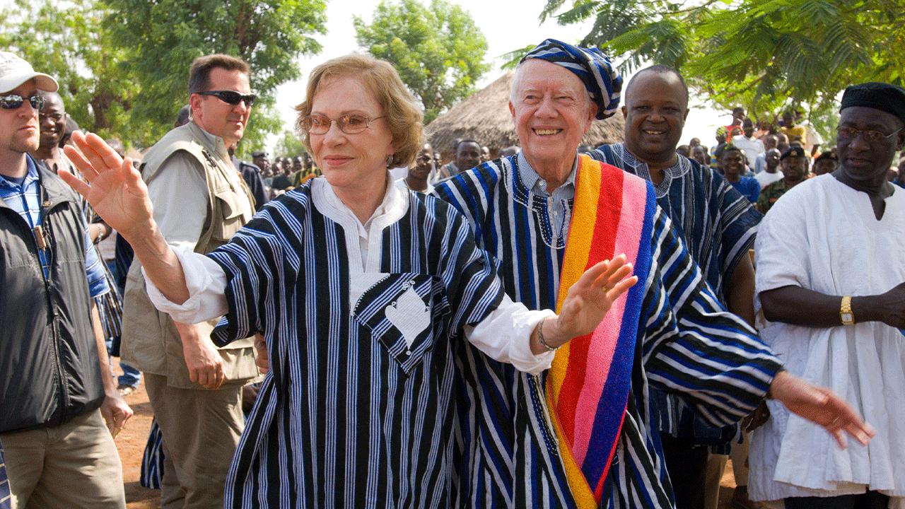 Former U.S. President Jimmy Carter and former First Lady Rosalynn Carter wear traditional Ghanaian attire, a gift from the chief of Tingoli village in northern Ghana, where The Carter Center, in partnership with Ghana's Ministry of Health, has worked to eradicate Guinea worm disease and eliminate trachoma. The Carters visited the village Feb. 8, 2007, as part of a two-week health tour of remote African villages.