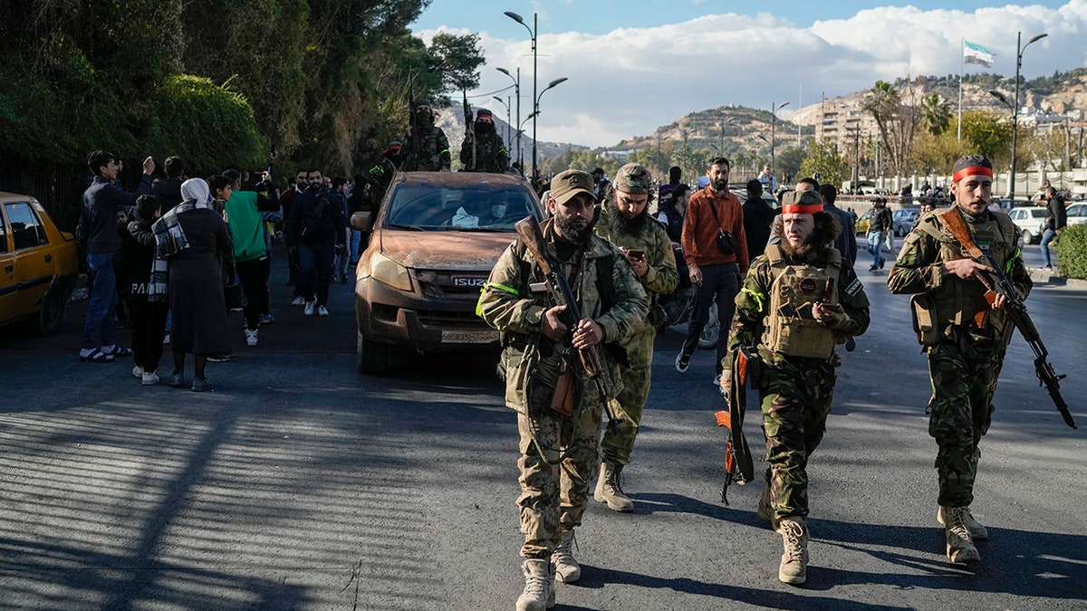 Syrian fighters walk in Damascus