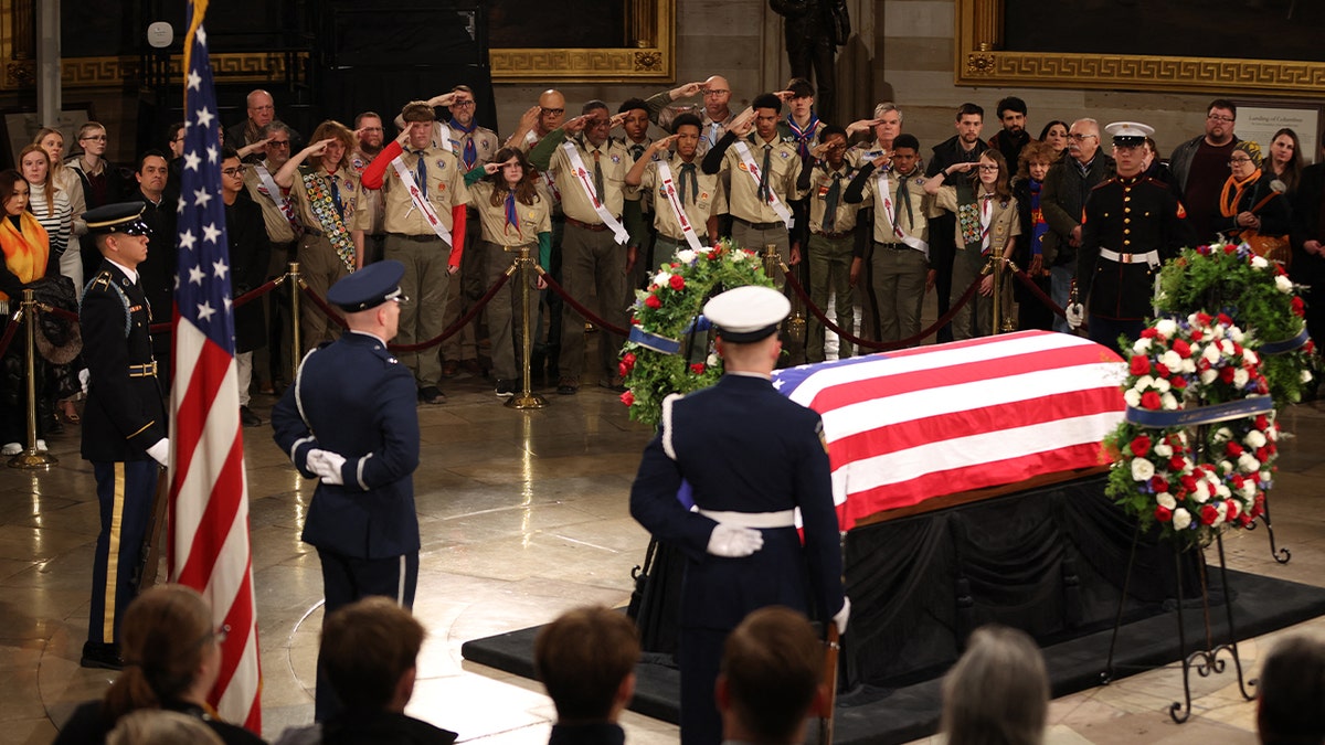 A Scout troop salutes as they pay their respects in front of the flag-draped casket at the Lying in State Ceremony for former President Jimmy Carter at the US Capitol Rotunda