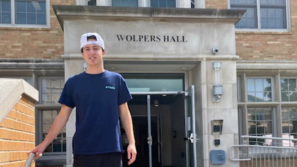 Danny Santulli standing in front of his college.