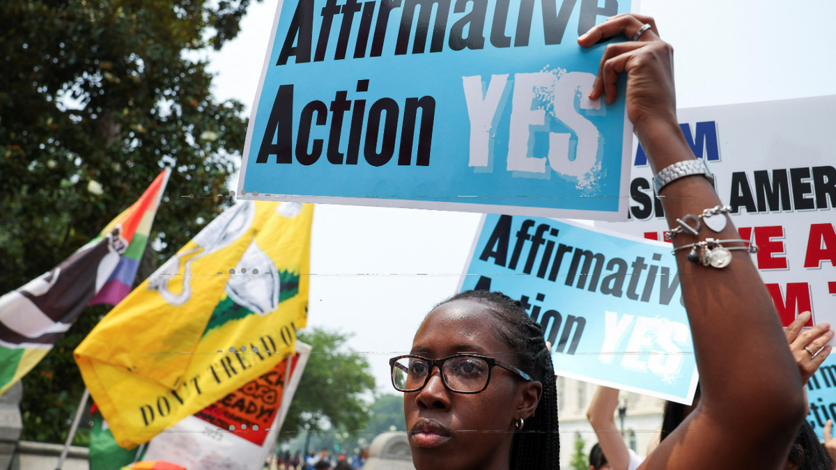 an activist holds a sign promoting affirmative action